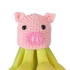 a crocheted pig head sitting on top of bananas