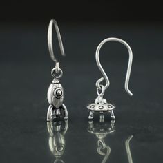 Sterling silver earrings in the shape of spaceship and rocket.  Dimensions ovni: 8 X 9 mm. Dimensions rocket: 15 X 5 mm. All our jewelry is hand-made and so sizes may vary from the standard slightly. If you have any questions about this product do not hesitate to contact us. Earrings Space, Fork Ring, Holiday Science, Science Decor, Galaxy Earrings, Science Jewelry, Rocket Ship, Glitter Earrings, Skull Jewelry