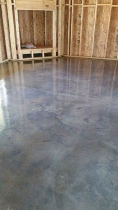 an empty room with wooden walls and flooring in the process of being painted gray