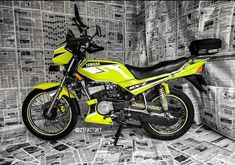 a yellow and black motorcycle is parked in front of newspaper wallpapered with newsprints