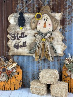 a scarecrow is hanging on the wall next to hay bales and pumpkins