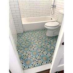 a white toilet sitting next to a bath tub in a bathroom