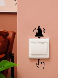 a wall with a light switch and a hand pressing the button to turn on it