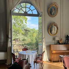 a dining room with a table and chairs in front of a large window that looks out onto a wooded area