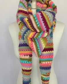 a multicolored crocheted scarf on a mannequin