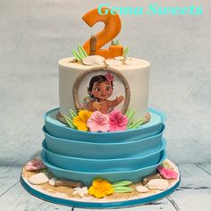 there is a two tiered cake with an image on the top and flowers around it