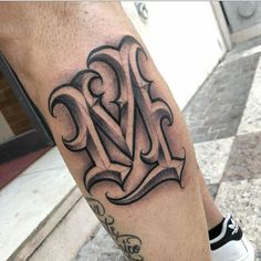 a man's leg with a black and grey tattoo design on the lower leg