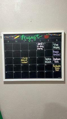 a blackboard with chalk writing on it and magnets attached to the wall