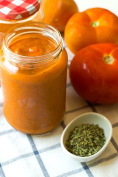 there is a jar of sauce next to some oranges and other food on the table