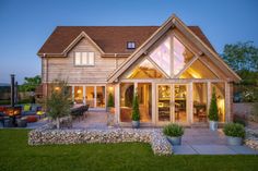 a house that is lit up at night with lights on the front and side windows