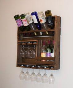 several wine glasses and bottles are hanging on a wooden shelf with two rows of wine glasses