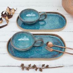 two blue dishes with gold spoons on them