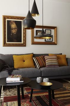 a living room filled with furniture and pictures hanging on the wall above it's coffee table