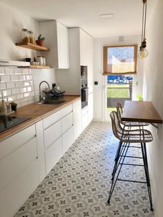 a kitchen with white cabinets and tiled flooring