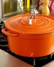 an orange casserole sitting on top of a stove