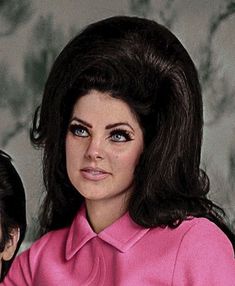 two women in pink shirts are posing for a photo together with one woman's head tilted to the side