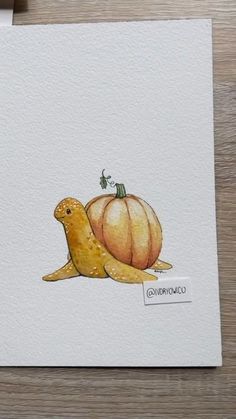 a watercolor painting of a snail with a pumpkin on it's back, sitting next to a piece of paper