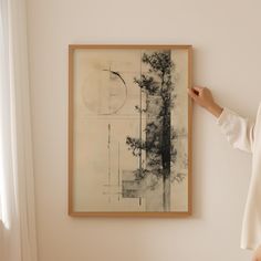 a woman standing next to a painting on the wall