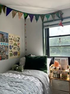 a bed room with a neatly made bed and lots of pictures on the wall above it