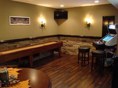 a game room with two arcade machines and several stools in front of the table