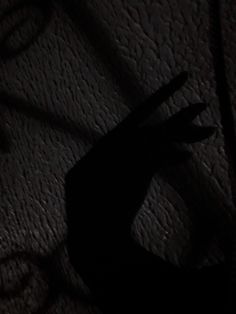 the shadow of a person's hand on a bed