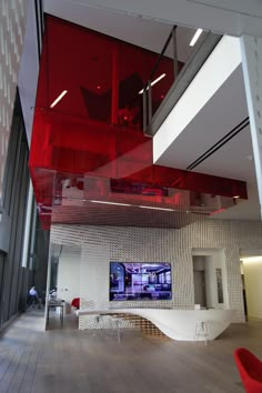 the interior of an office building with red glass panels on the ceiling and stairs to the second floor