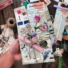 a person holding up a book with some stickers on it and flowers in the middle