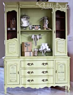 a green china cabinet sitting on top of a white floor