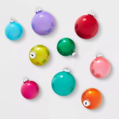 six different colored christmas ornaments on a white surface