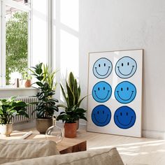 a living room with plants and pictures on the wall