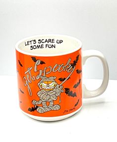 an orange and white coffee mug with the words let's scare up some fun on it