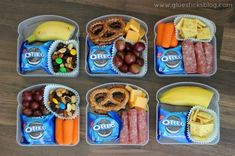 four plastic containers filled with food on top of a wooden table