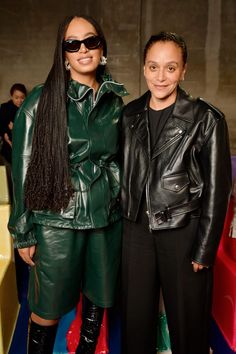 two women standing next to each other in leather outfits