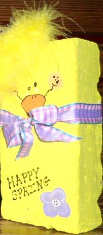 a yellow box with a purple ribbon and a ducky on the front that says happy spring