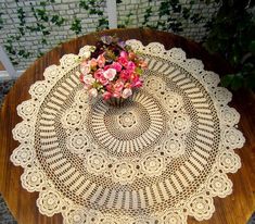 a doily on a table with flowers in it