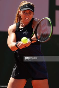 a woman hitting a tennis ball with her racquet on the court during a match