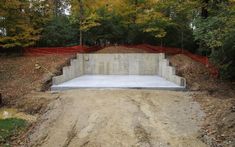 a concrete slab is placed in the middle of a dirt field with trees around it