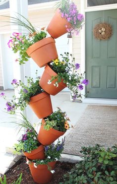 an upside down planter filled with potted plants on the side of a house