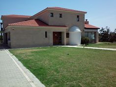 a large house sitting on top of a lush green field