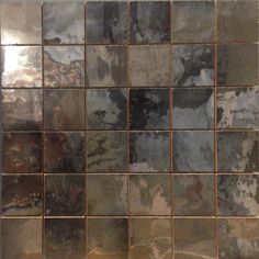 a tile wall that has different colors and shapes on it, including grays and browns