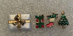 three christmas brooches are laying on the floor next to each other and one has a present in it