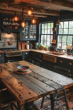 a rustic kitchen with black cabinets and wooden table