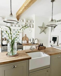 a kitchen filled with lots of counter top space and wooden counters topped with vases full of flowers