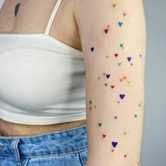 a woman's arm with small hearts painted on the back of her left arm