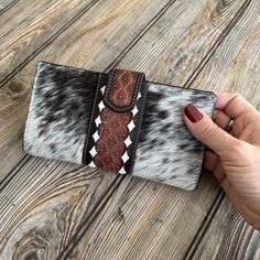 Travelteli is proud to introduce our newest designed Artisan Hand-Tooled Leather and Cowhide Women's Wallet. Each wallet is a testament to the beauty of handcraftsmanship, featuring an intricate hand-tooled floral design that exudes a Western aesthetic. The genuine cowhide front panel flaunts the natural and unique patterns of the hide, ensuring that no two wallets are exactly alike. Our wallet is designed for the modern woman who appreciates the beauty of artisanal goods. The wallet measures a Brown Wallets With Snap Closure As Gift, Brown Wallet With Snap Closure As Gift, Brown Wallet With Snap Closure, Brown Leather Wallets With Magnetic Closure, Brown Leather Wallet With Magnetic Closure, Brown Bifold Wallet With Magnetic Closure, Brown Clutch Wallet With Snap Closure, Notebook Bag, Western Aesthetic