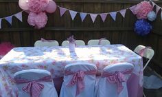 a table set up with pink and white decorations