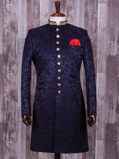 a man's blue indoi sherwa with red and gold buttons on the lapel