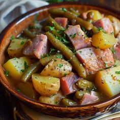 a bowl filled with meat, potatoes and green beans