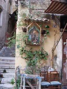 an old building with ivy growing on the outside and stairs leading up to it's entrance