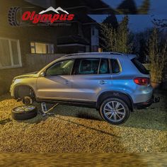 a silver car parked in front of a house at night with the word gymus on it